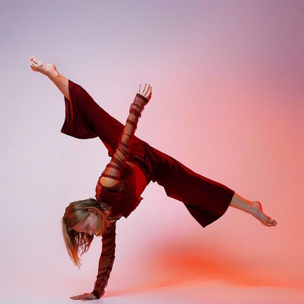 Woman in a dynamic yoga flow pose with graceful movement.